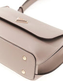 Close-up of a taupe pebbled leather handbag with gold-tone hardware and a small metal logo plaque on the flap, set against a plain white background.