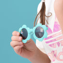 Child holding turquoise sunglasses with cartoon character lenses against a blue background