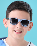 Child wearing Batman sunglasses against a blue background